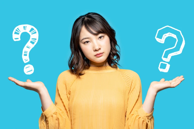 A woman in a yellow top stands against a blue background, holding her hands up with a questioning expression. Large white question marks are illustrated near each hand, symbolizing confusion or decision-making.