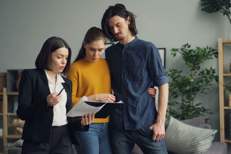 a couple reviewing documents with a real estate agent